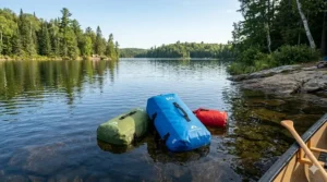 60L dry bag floating on water during a canoe camping adventure.
