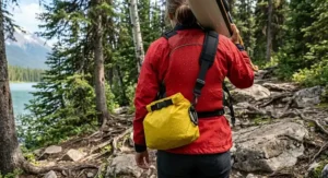 A paddler wearing a small dry bag with a shoulder strap during a portage.