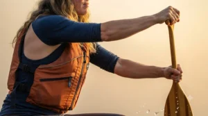Illustration of a paddler with high-cut arm mobility wearing an ergonomic adult PFD for canoeing.