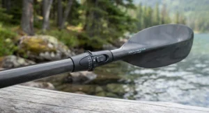 Close-up view of a lightweight carbon fiber kayak paddle for touring, highlighting the ergonomic ferrule and blade shape designed for long-distance paddling in Canada.