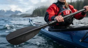 Illustration demonstrating the feathered blade angle adjustment on a two-piece kayak paddle for touring against headwinds on Pacific waters.