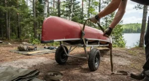 Instructional view demonstrating how to secure a canoe to a cart for portaging safely before a backcountry trip.