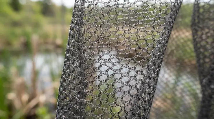 A close-up of a no-see-um mesh jacket fabric showing density near a wetland habitat.
